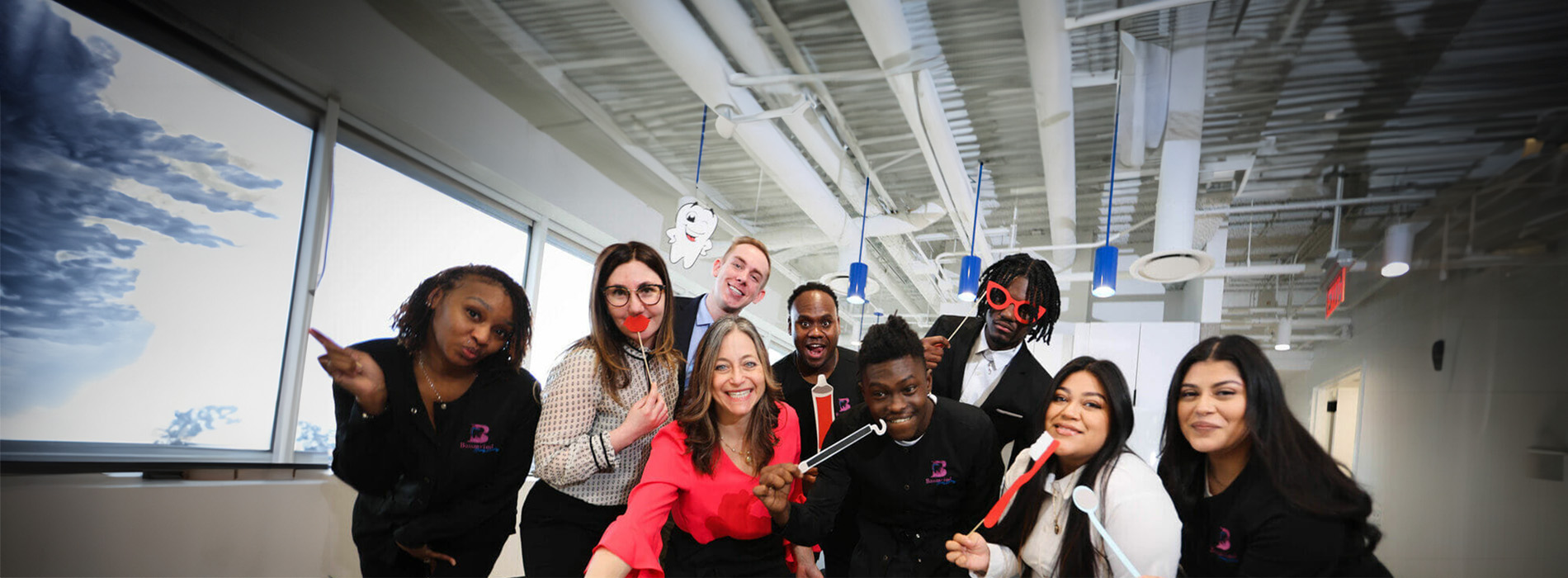 The image is a collage of six separate photographs featuring a group of people posing for photos in an indoor setting, with the top photo showing a person pointing at something and the rest capturing individuals or small groups smiling or looking directly at the camera.