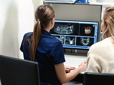 Two individuals, one male and one female, sitting in front of a computer screen displaying medical imagery.