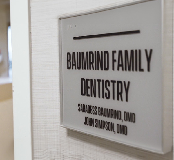 The image shows a sign for  Baumind Family Dentistry  with the names of dentists listed below.