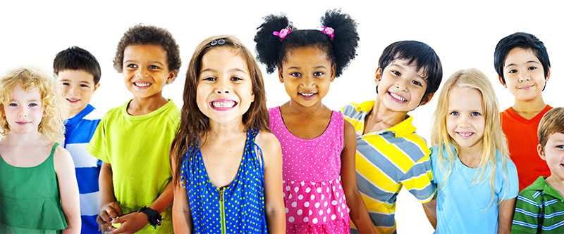 The image features a group of children and adults posing together, smiling and looking directly at the camera.