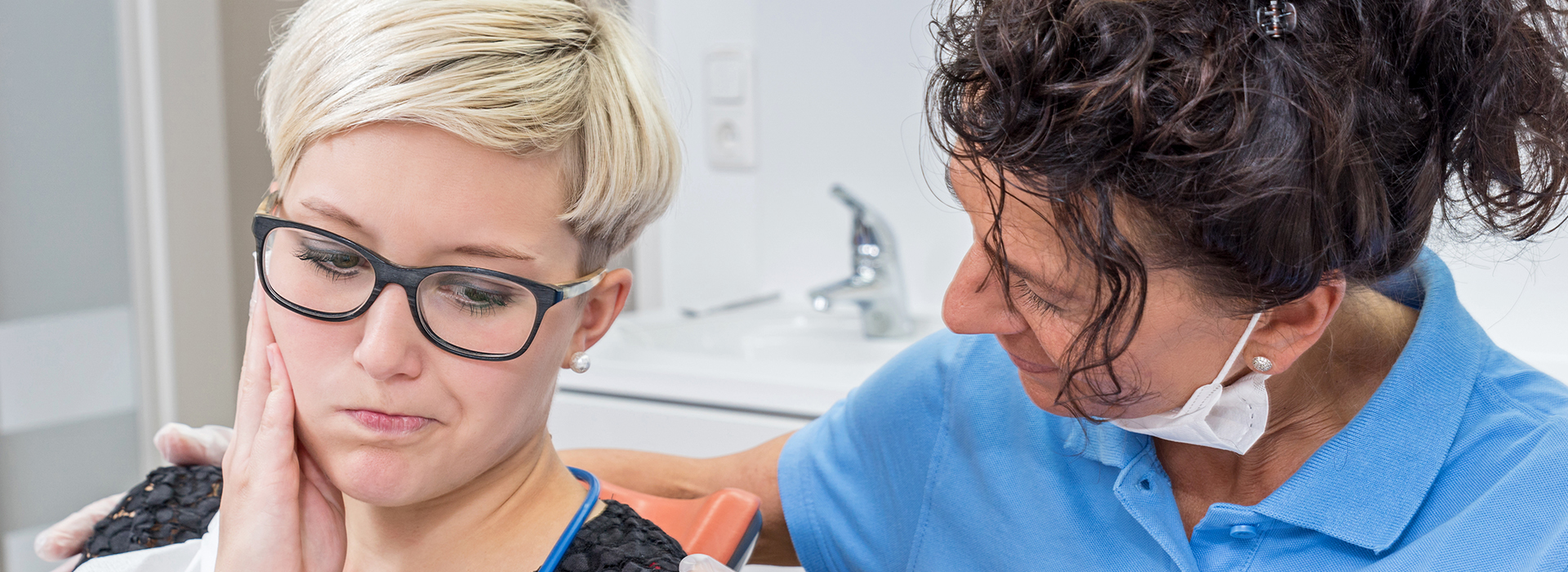 A woman receiving dental care from a professional, with a focus on the dental chair and equipment.