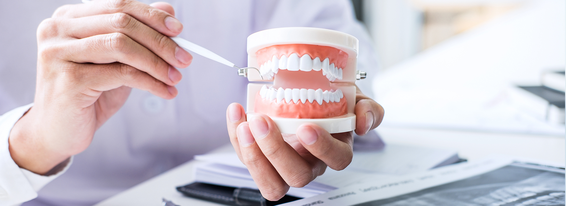 A person holding a toothbrush, with a focus on dental care and oral hygiene.